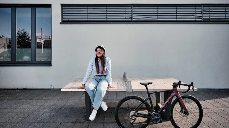 Frau auf Tischtennisplatte mit Gravelbike