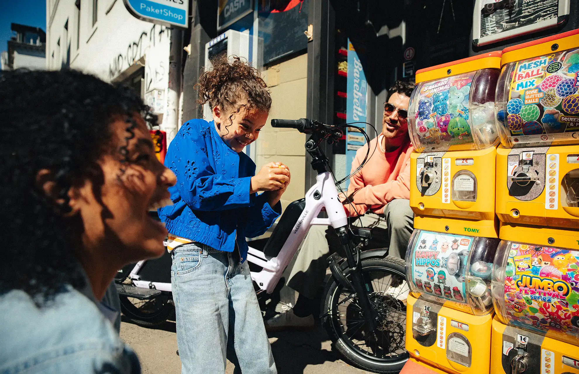 Familie am Kaugummiautomaten mit Lastenrad