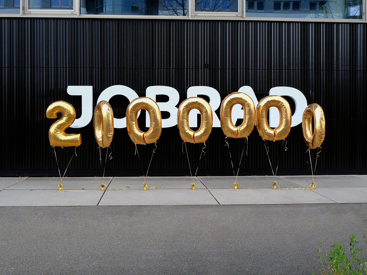 gelbe Luftballons bilden 2 Millionen und fliegen vor dem JobRad-Logo